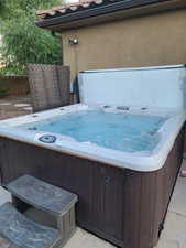 View of patio with a hot tub