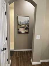 Hall with dark wood-style floors and baseboards