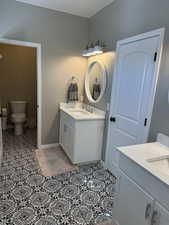 Full bathroom featuring two vanities and light tile patterned floors