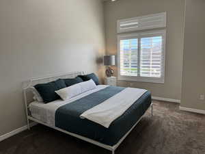 Bedroom featuring dark carpet
