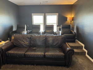 Carpeted living room featuring baseboards and a textured wall
