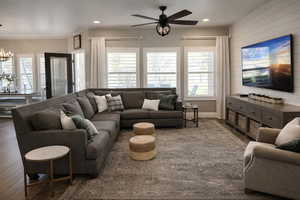 Living room featuring wood finished floors, a ceiling fan, and suspended lighting