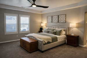 Bedroom featuring ceiling fan and dark colored carpet