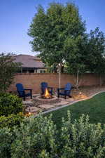 Fenced backyard featuring a fire pit and a patio