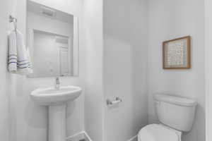 Half bathroom featuring toilet and baseboards