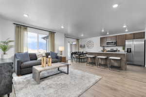 Living room featuring light wood-style flooring and recessed lighting