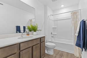 Bathroom with vanity, shower / tub combo with curtain, and light wood-style flooring
