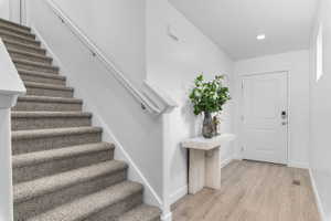 Foyer entrance with stairway and light wood finished floors