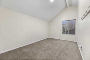 Empty room with carpet and beamed ceiling
