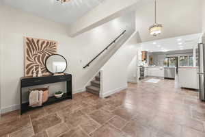 Staircase with a high ceiling, recessed lighting, and stone finish floors