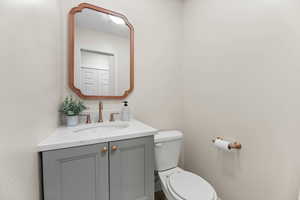 Half bathroom featuring vanity and toilet