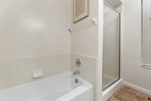 Full bath with a bath, a shower stall, and light tile patterned flooring