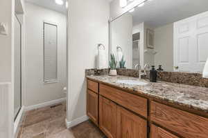 Bathroom featuring vanity and a shower stall