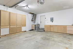 Garage featuring a garage door opener and electric panel