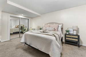 Carpeted bedroom featuring a closet and a textured ceiling