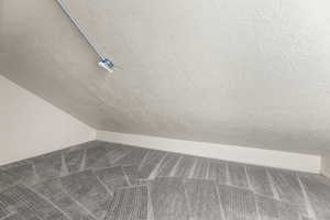 Detailed view of carpet flooring and a textured ceiling