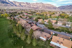 View of property location featuring mountains, a local golf course, and nearby suburban area