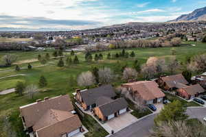 Aerial perspective of suburban area featuring a mountainous background and a local golf course