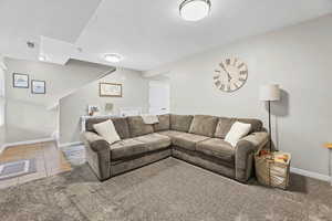 Living area with light tile patterned floors and light colored carpet