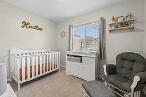 Bedroom with a crib and light carpet