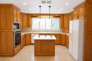 Kitchen featuring wood finish cabinets, a kitchen island, and light countertops