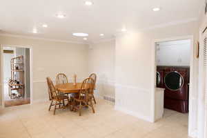 Dining space featuring ornamental molding, independent washer and dryer, recessed lighting, and light tile patterned floors