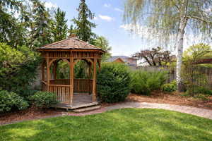 Fenced backyard with a gazebo and a wooden deck