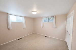 Unfurnished bedroom with multiple windows, carpet floors, and a closet