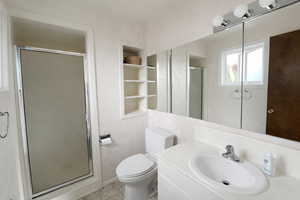 Bathroom with built in features, vanity, and a stall shower