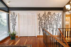 Hall with an upstairs landing and wood finished floors