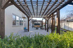 Fenced backyard with a pergola, a patio area, and an outdoor fire pit