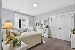 Bedroom featuring dark colored carpet and a closet