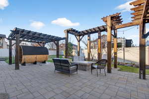Fenced backyard with a pergola, a patio, and an outdoor living space with a fire pit