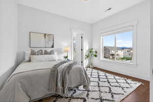Bedroom featuring dark wood-style floors and baseboards