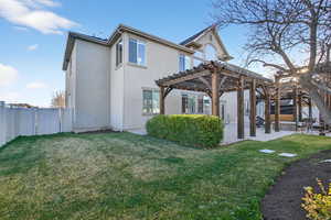 Rear view of house featuring a pergola, a gate, stucco siding, a fenced backyard, and a patio