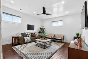 Living area with dark wood-type flooring, ceiling fan, and recessed lighting