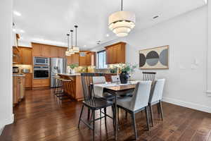 Dining room with dark wood finished floors and recessed lighting