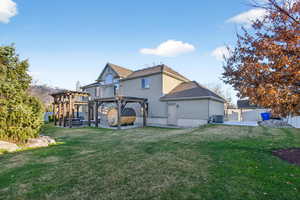 Rear view of house featuring a patio area, a pergola, and stucco siding