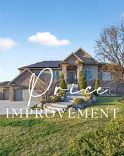 Craftsman-style house featuring stone siding, solar panels, an attached garage, a front yard, and concrete driveway