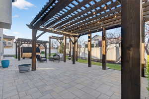 Fenced backyard with a pergola, a patio area, and an outdoor fire pit