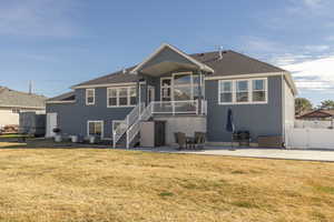 Back of property with a patio, a gate, stucco siding, a balcony, and roof with shingles