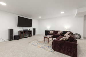 Living area featuring light carpet and recessed lighting