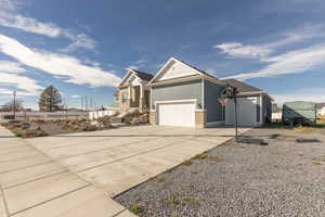 View of front of home with concrete driveway and a garage