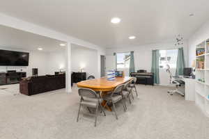Dining room with light colored carpet, a desk, and recessed lighting