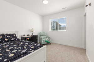 Bedroom featuring light carpet and baseboards