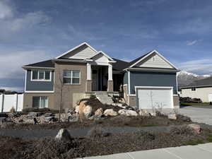 Craftsman-style home featuring brick siding, concrete driveway, a garage, and covered porch