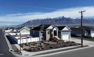 View of front facade with a residential view, a mountain view, and driveway