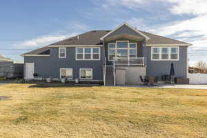 Rear view of property featuring a patio area, roof with shingles, and stucco siding