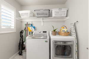 Laundry room featuring independent washer and dryer and light tile patterned floors