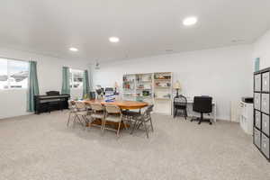 Dining area with light carpet and recessed lighting